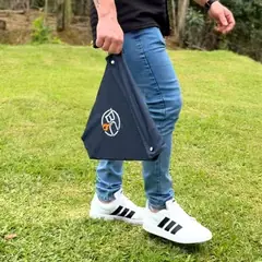 Pessoa carregando a B.C ONYX desmontada dentro da bag, segurando pela alça, num gramado