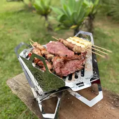 B.C ONYX montada sobre uma mesa no jardim, com picanha, espetinhos e queijo coalho na grelha